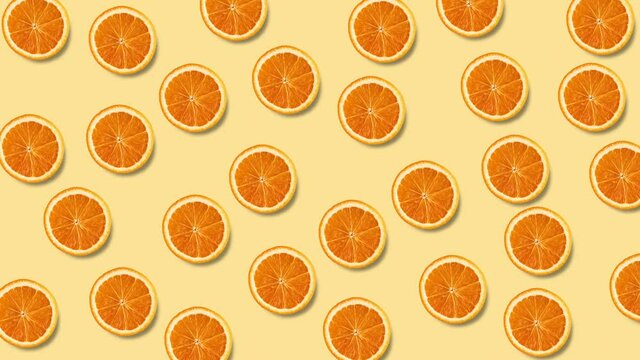seamless looping animation with many orange slices that wiggle on a pastel yellow background, copy space