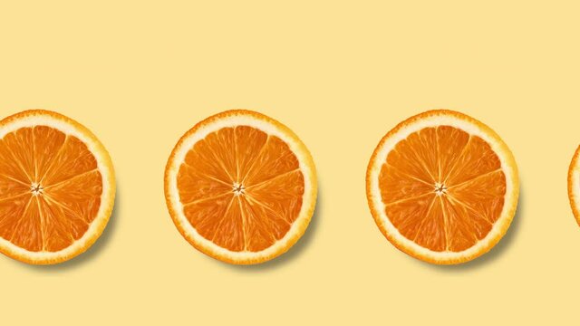 seamless looping animation with many orange slices on a pastel yellow background, copy space
