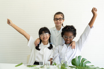 Cheerful group of diversity children scientists learning science, doing analysis for germs with glassware laboratory. Asian, African American, caucasian girl scientist. Scientific experiment concept