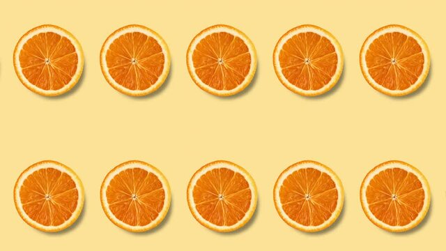 seamless looping animation with two rows of orange slices on a pastel yellow background, copy space