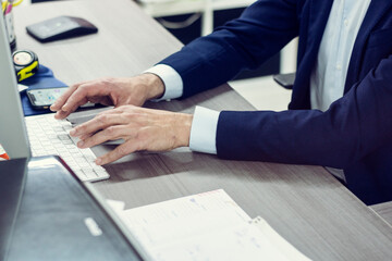 Suit dressed man using the keypad of a computer