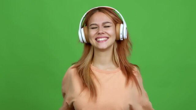 Teenager girl listening music with headphones celebrating a victory and surprised to be successful over isolated background