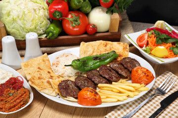 grilled meatballs with rice pilaf and fried potato and grilled tomata green pepper