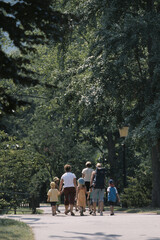 Fototapeta premium Drei Frauen gehen mit Kindern durch einen Park