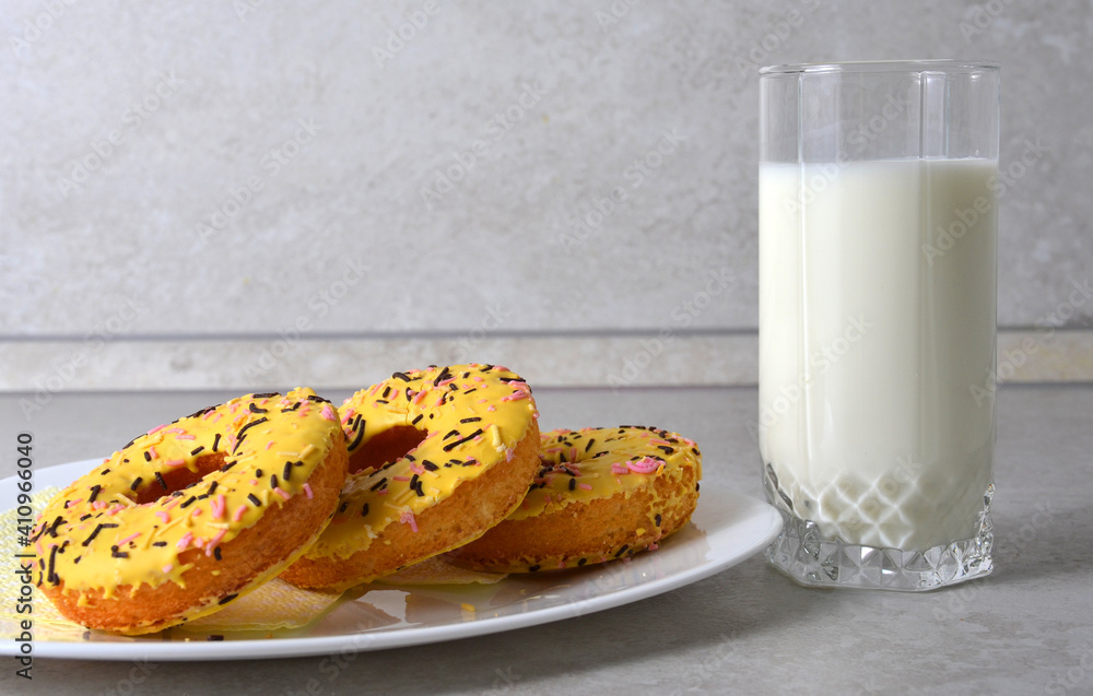 Wall mural yellow donuts on a plate and milk .