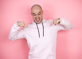 Young bald man wearing casual sweatshirt over pink isolated background looking confident with smile...