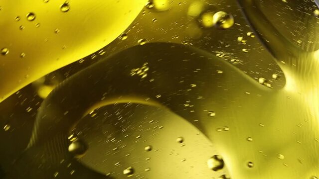 Bright yellow moving circles liquid bubbles. Olive oil, beer, drink close-up macro photography.
