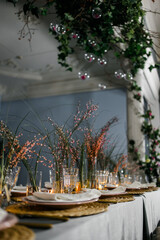 
served table with burning candles and fresh flowers for a festive dinner