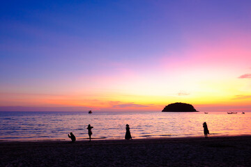 Silhouette of happy young people enjoy on Kata beach at sunset, Phuket, Thailand.