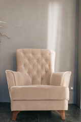 Pink scarf and beige pillow on gray armchair at the corner of living room