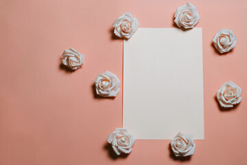 Creative layout with yellow roses and a sheet of paper. On a light orange background. Floral arrangement with copy space.