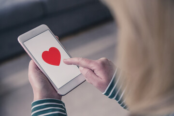 Girl using a touchscreen mobile phone to find love in online dating app - obrazy, fototapety, plakaty