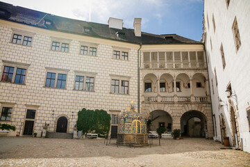 Obraz premium Courtyard of medieval castle and chateau, historical palace complex, arcades and white renaissance archs with ornamental water well, Jindrichuv Hradec, South Bohemia, Czech Republic