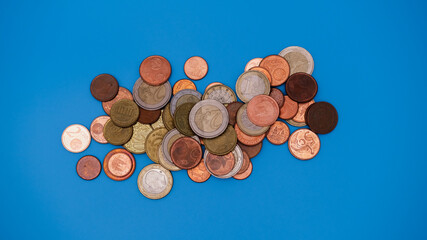 Coins on blue background. Top view