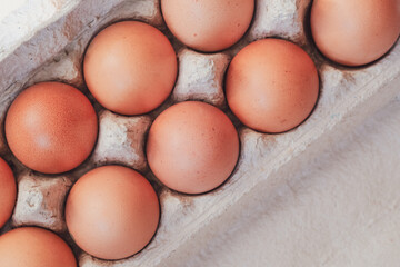 Closeup of raw brown eggs in egg box. Top view, copy space