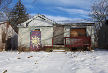 Abandoned and boarded-up Brightmoor home with a flower mural in Detroit
