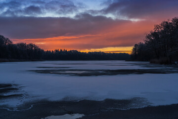 Sunrise on a frosty morning with a frozen lake.
