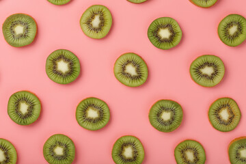 Ripe kiwi slices in patterns on a pink background.