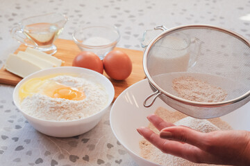 Sifting flour. Ingredients for homemade pancakes. Cooking for someone special concept