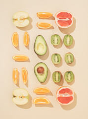 Neatly arranged freshfruit on sandy colored background. Minimal flat lay.