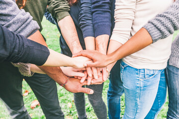 Closeup of multiracial people putting hands on stack  - Group of friends with mixed races getting ready for teamwork effort - Friendship and lifestyle concepts