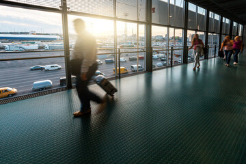 Blurred people walking at airport terminal - Travel and transportation concept during coronavirus pandemic with travel restrictions and corridor - Passengers going into quarantine after flight