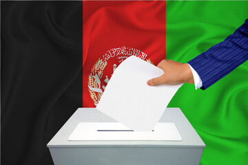 Elections in the country - voting at the ballot box. A man's hand puts his vote into the ballot...