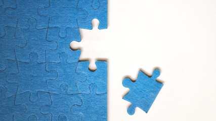 Top view flat lay of jigsaw puzzle with one piece missing .Concept of absence and...
