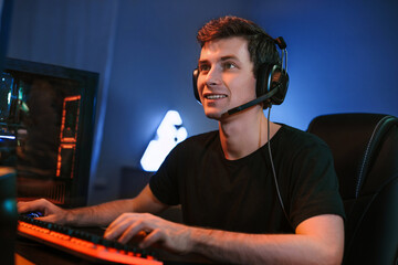 Young Caucasian handsome professional cybersport player training or playing online video game on...