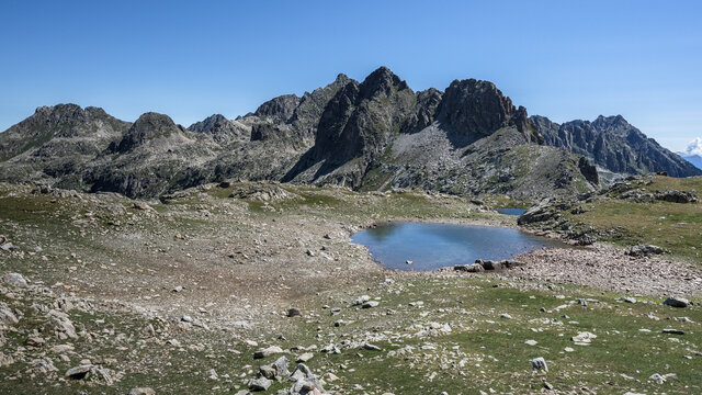 View of Port de Ratera (Ratera pass) and the glacial lake as seen from GR11 trail to refuge Colomers, Aiguestortes and Estany de Sant Maurici National Park, Pyrenees, Spain.