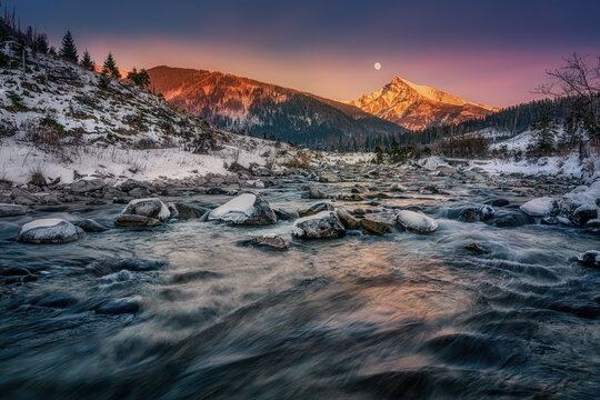 Krivan peak with the moon in full over a mountain river in High Tatras