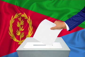 Elections in the country - voting at the ballot box. A man's hand puts his vote into the ballot...