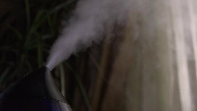 Steam from a modern air humidifier in dark room. Close-up, no people.