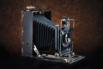 Old camera. Vintage camera open on a dark brown background.