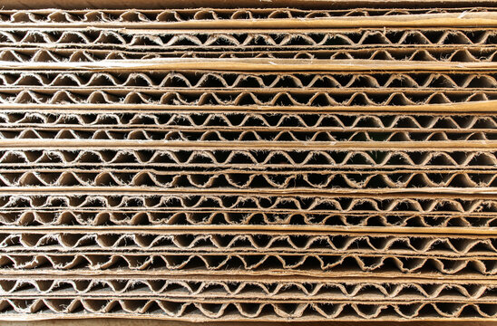 Endless side view of brown container paper box packaging material from shipping industrial. Recycle paperboard. Abstract art of wave striped horizontal lines texture.