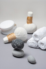 Fototapeta na wymiar Spa composition of herbal massage bags, a jar of salts, towels and stones.