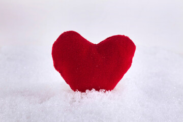 Toy plush heart on the snow. St. Valentine`s day concept. Text space.