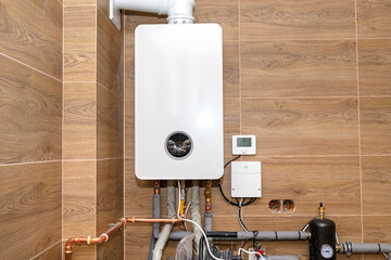 A modern gas boiler for natural gas, installed in a boiler room lined with ceramic tiles.