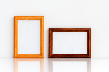 Two wooden frames with a white insert inside for text or drawing. Photo frame on a white wall background.