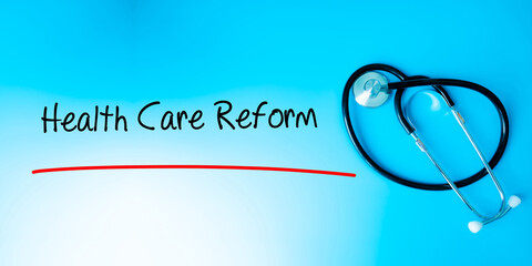 Health Care Reform Sign.Text underline with red line. Isolated on blue background with stethoscope....