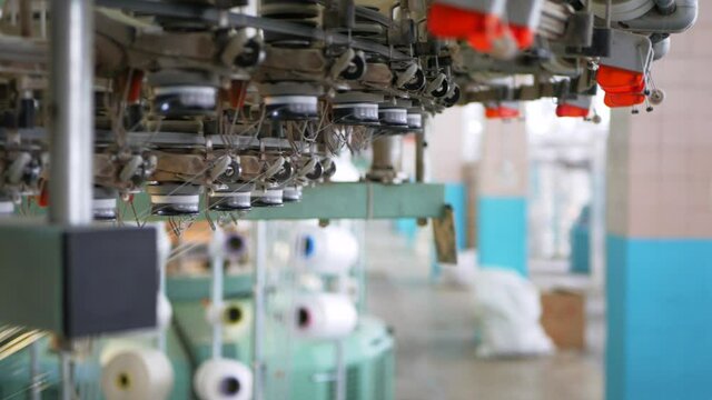 Weaving of fabric on cars. Production of fabric from threads at factory. Textile factory industry. Fabric making machines.