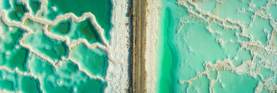 Panoramic aerial view of salt veins from 2 sides of a road that cross in the middle. Dead sea, Negev, Israel.
