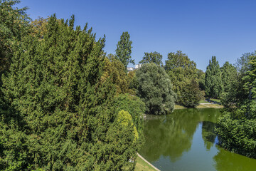 Obraz premium The artificial lake in Parc des Buttes-Chaumont - Public Park situated in northeastern Paris. It opened in 1867; it is fifth-largest park in Paris. France.