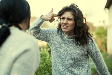 Irritated young woman asserting opinion to offended middle aged mother at home. Annoyed grown up...
