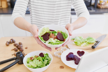 Obraz na płótnie Canvas Woman preparing vegetable salad in her kitchen. Healthy Food. Diet.Healthy lifestyle concept.Vegan Salad.Cooking At Home