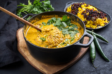 Traditional Indian chicken curry masala with saffron rice and berberis served as close-up in...