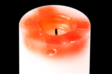 Candle white-red paraffin isolated on black background.