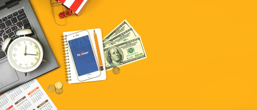 Kharkov, Ukraine - February 5, 2021: Payoneer application on Apple smartphone, online electronic finance payment sustem and service creative concept flat lay background, banner and copy space