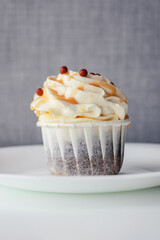 One chocolate cupcake in a cream cap in a paper form of corrugation