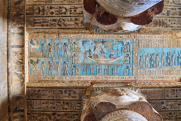 A blue ceiling in the temple of Dendera, depicting different Deities and the journey of the king in the solar boat in the sky, with two Hathoric columns facing it